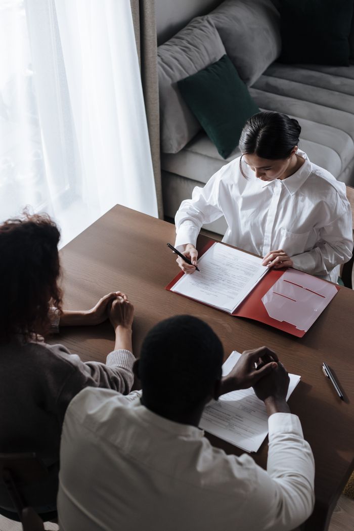 Services Business professionals in a meeting reviewing documents at a table.