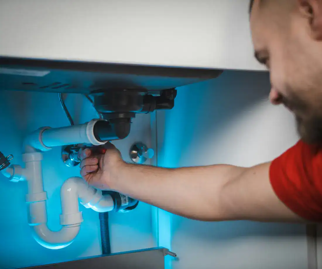 Plumber working under a sink