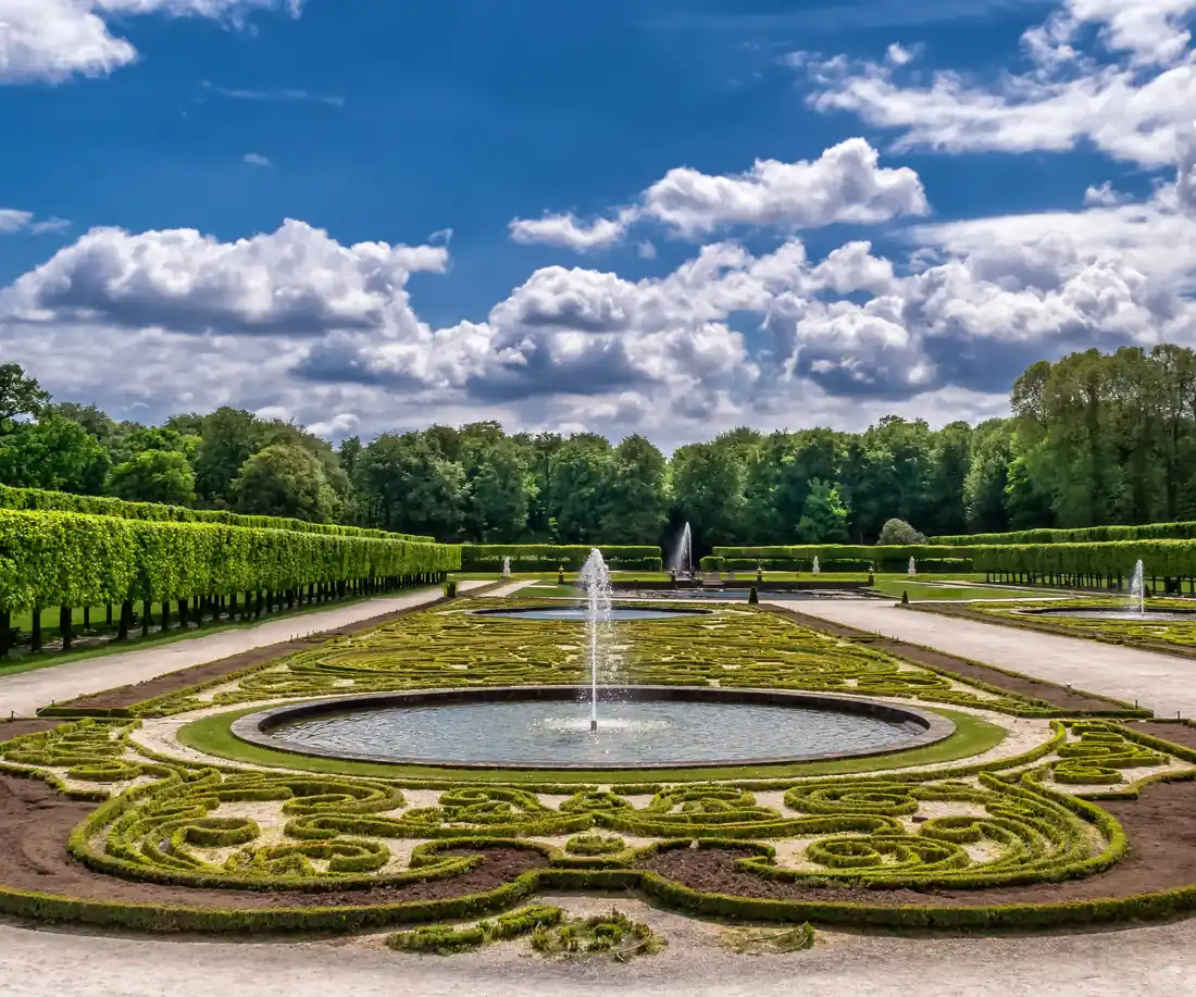 Landscaped garden with hedges, paths and a fountain