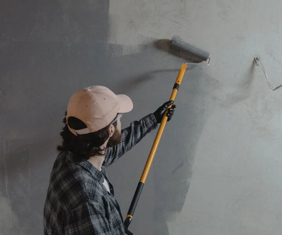 Decorator painting a wall with a roller